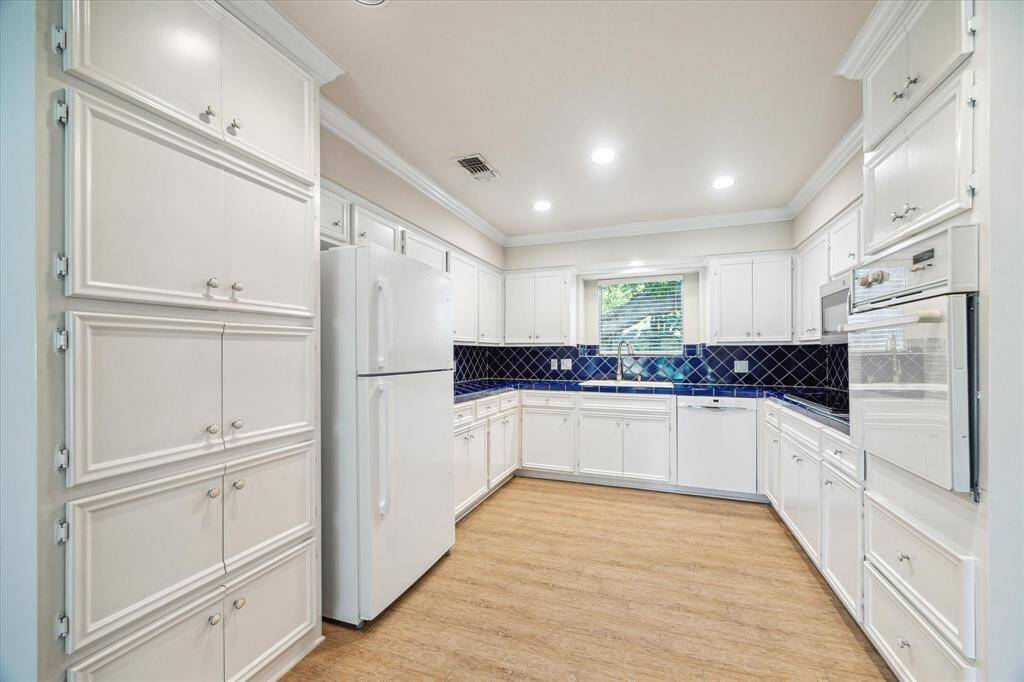 Kitchen with ample storage, new cooktop and refriferator. Has a window with a view of the frontyard