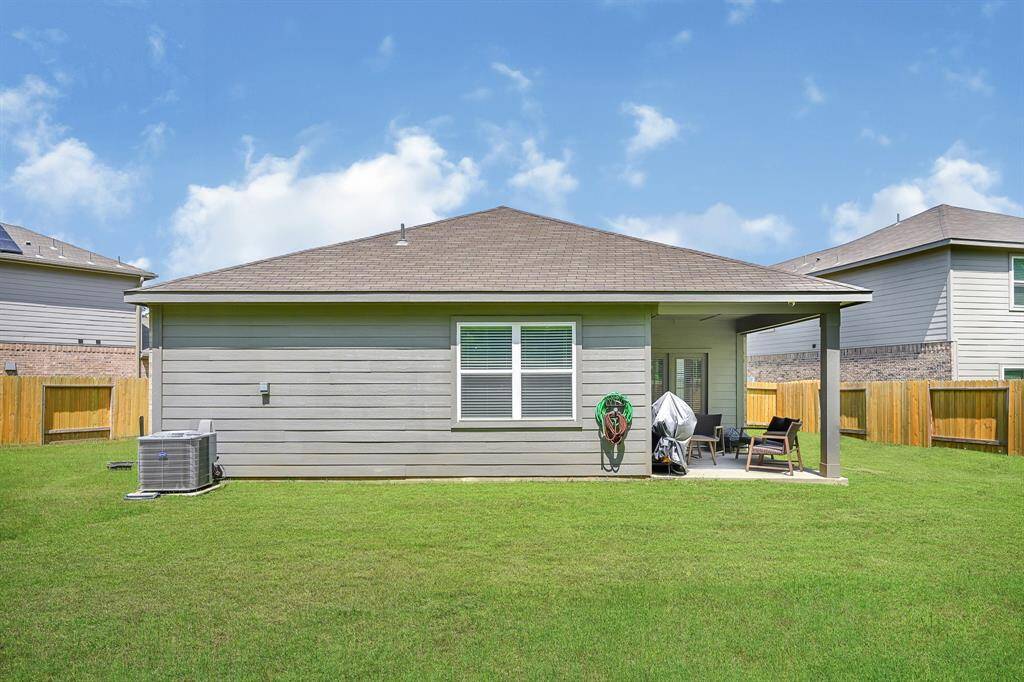 The back of the home features a covered porch and a thick, well cared for lawn.