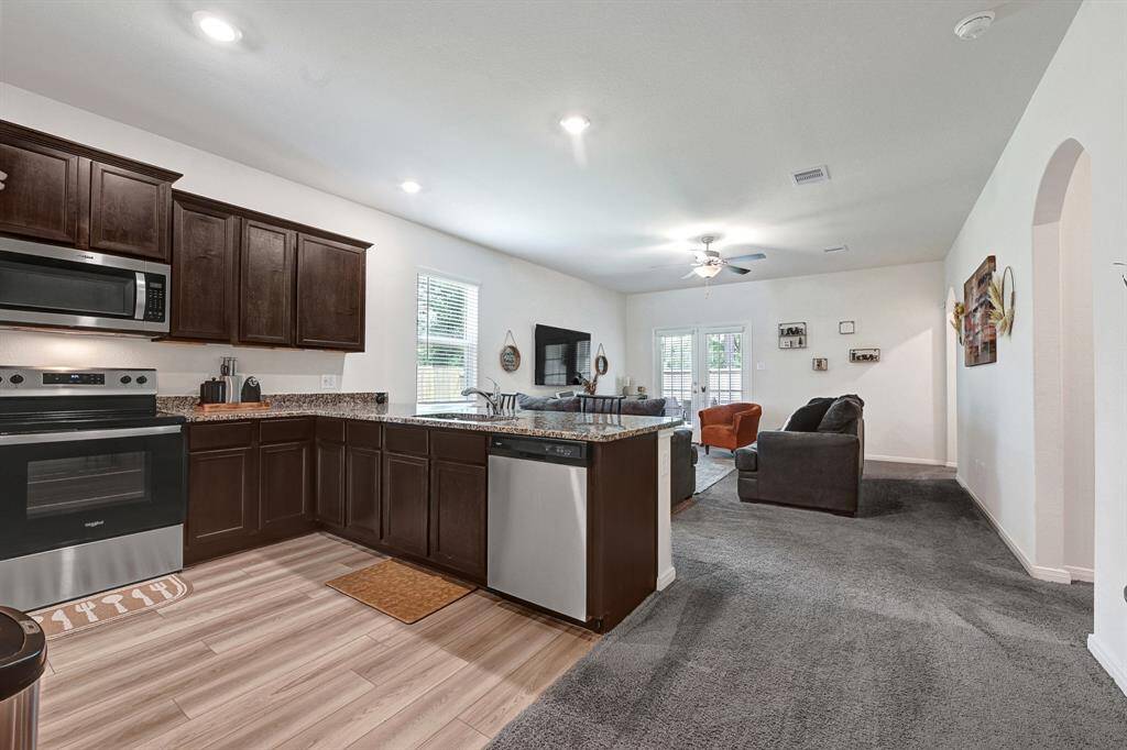 The open floorplan features recessed lighting and maintains a cozy feel from the soft, clean carpeted floors.