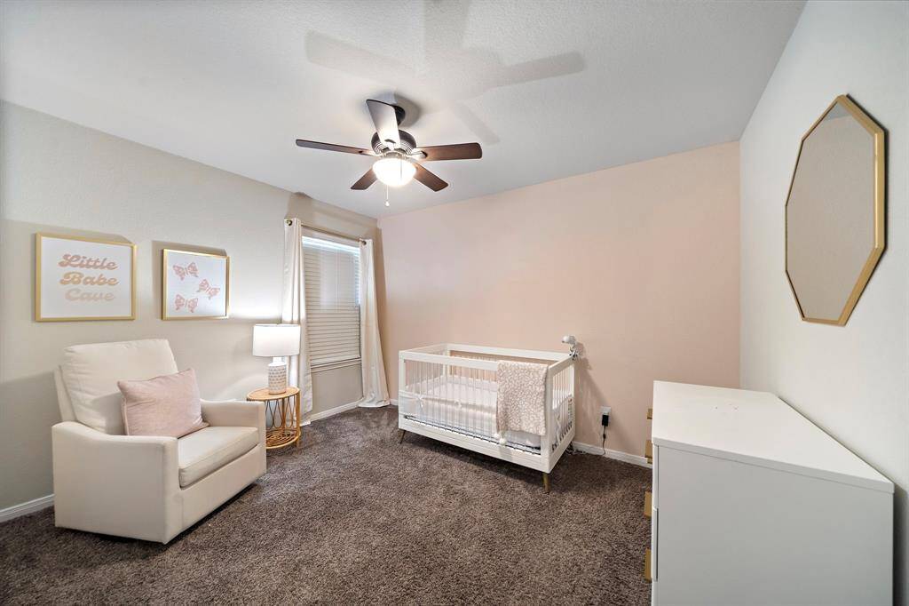 Designed for comfort and versatility, this secondary bedroom features plush carpet flooring, a ceiling fan, and ample natural light.