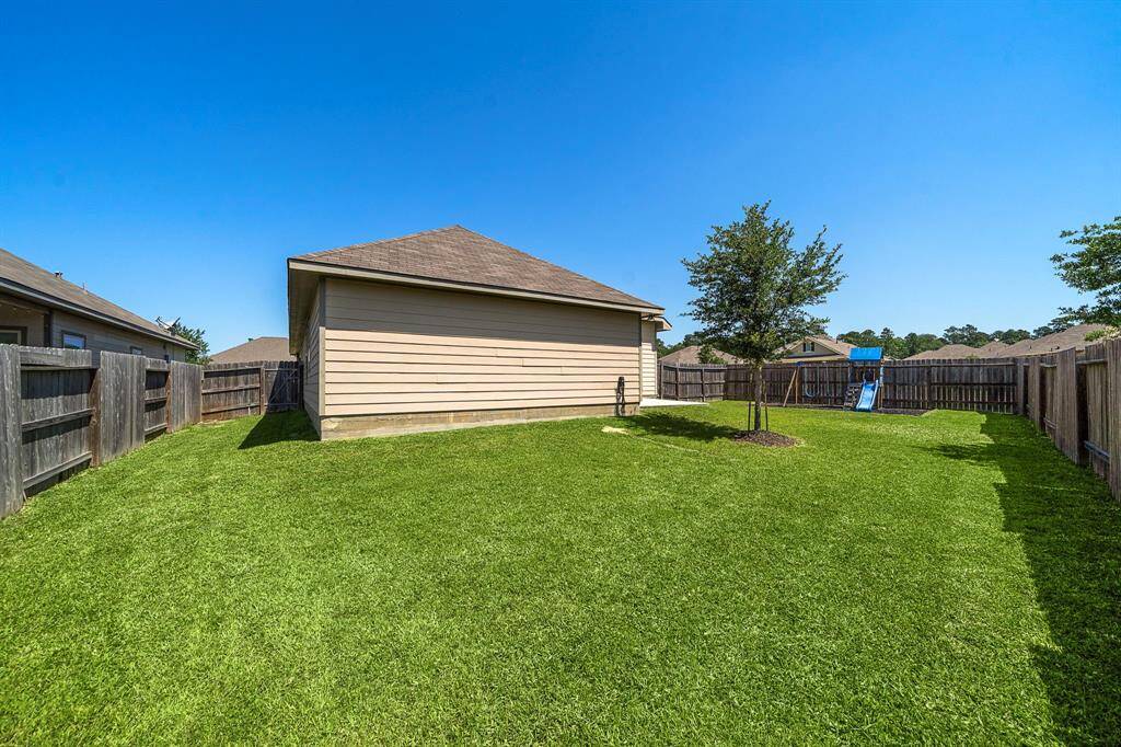 Spacious side yard on the corner lot offers extra room for recreation, gardening, or outdoor gatherings. Fully fenced for privacy and featuring a well-placed tree, this versatile green space easily connects to both the detached garage and backyard play area.