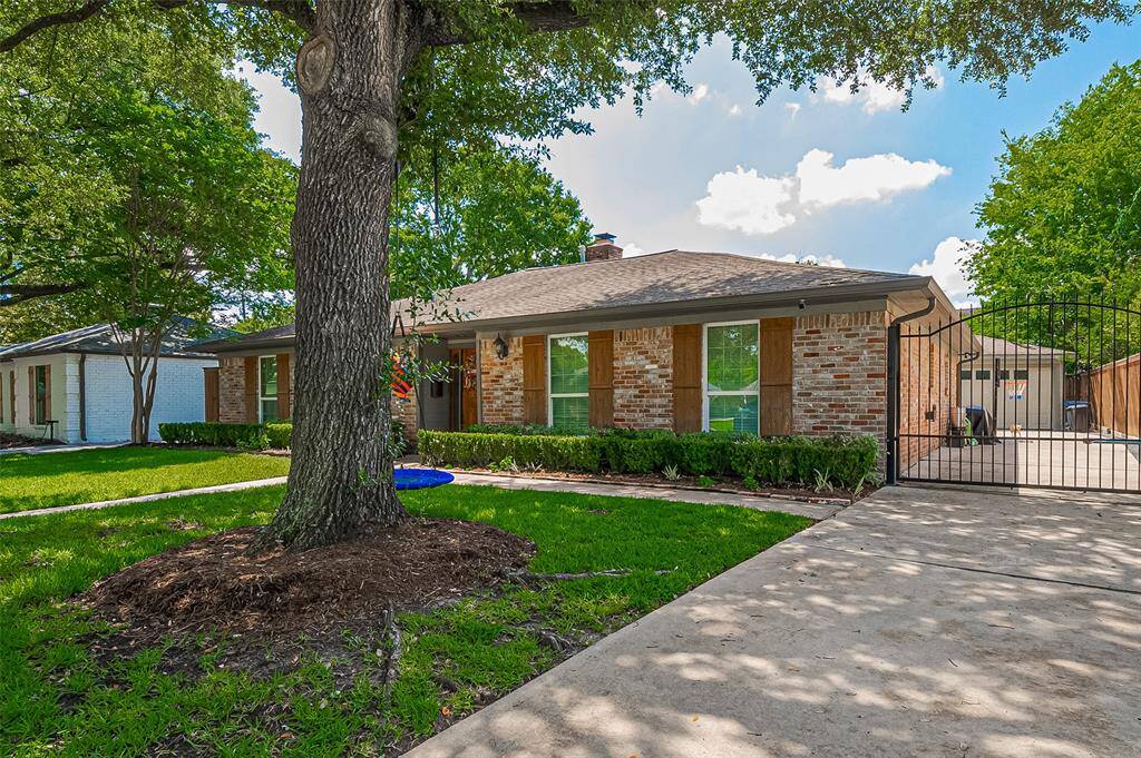 The property includes a gated driveway leading to a garage and spacious backyard.