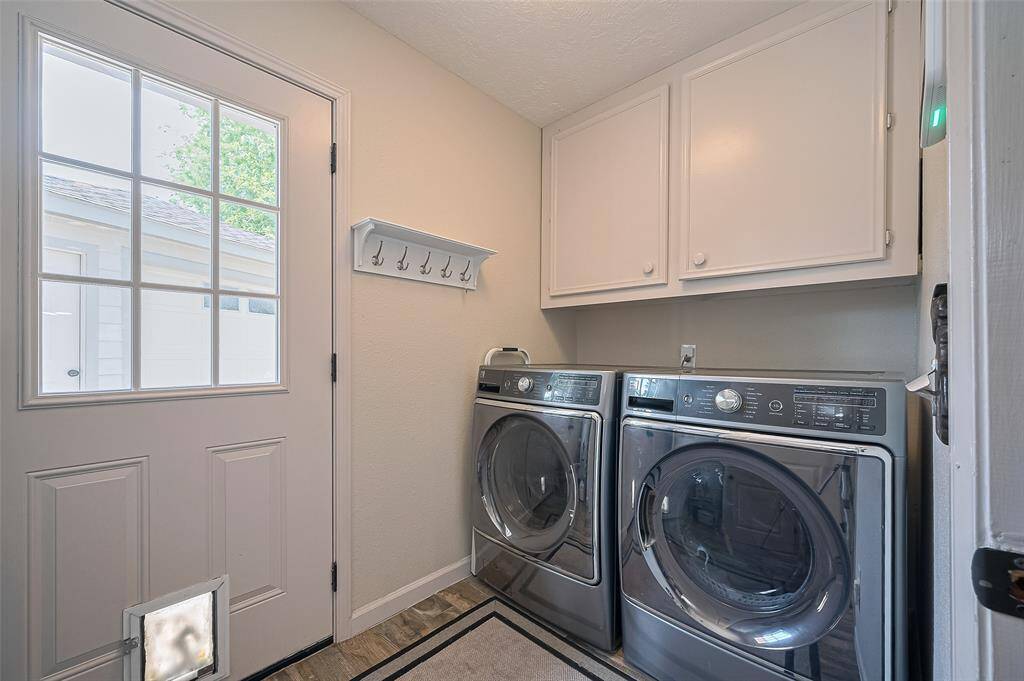 The utility room just off the kitchen offers excellent storage, with two large cabinets above the washer and dryer and a fully shelved closet on the opposite wall.