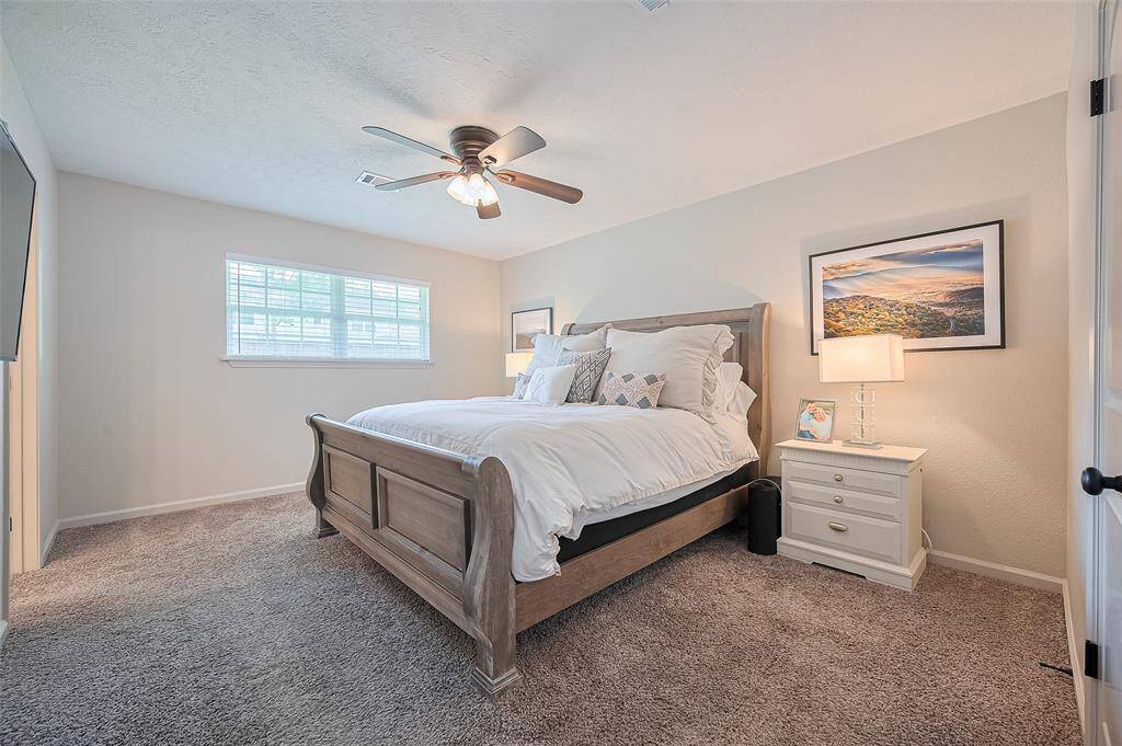 The spacious primary bedroom features a walk-in closet, ceiling fan with light fixture, and plenty of room for your dream bedroom furniture—all complemented by an airy layout and generous natural light.
