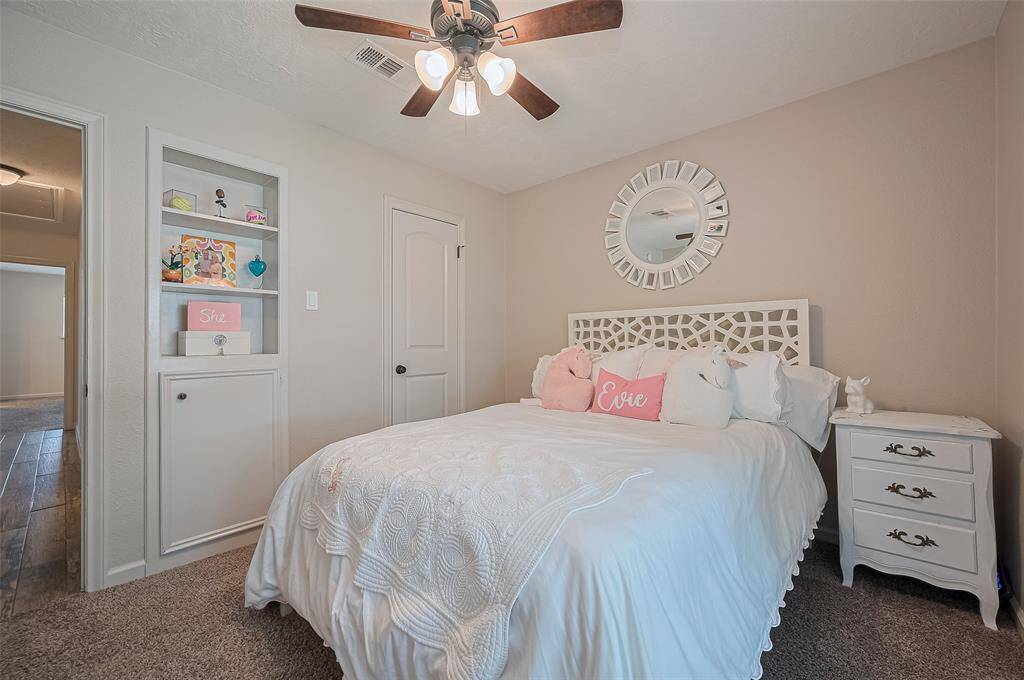 This secondary bedroom also offers a generous closet and a built-in shelf—perfect for storage and display.