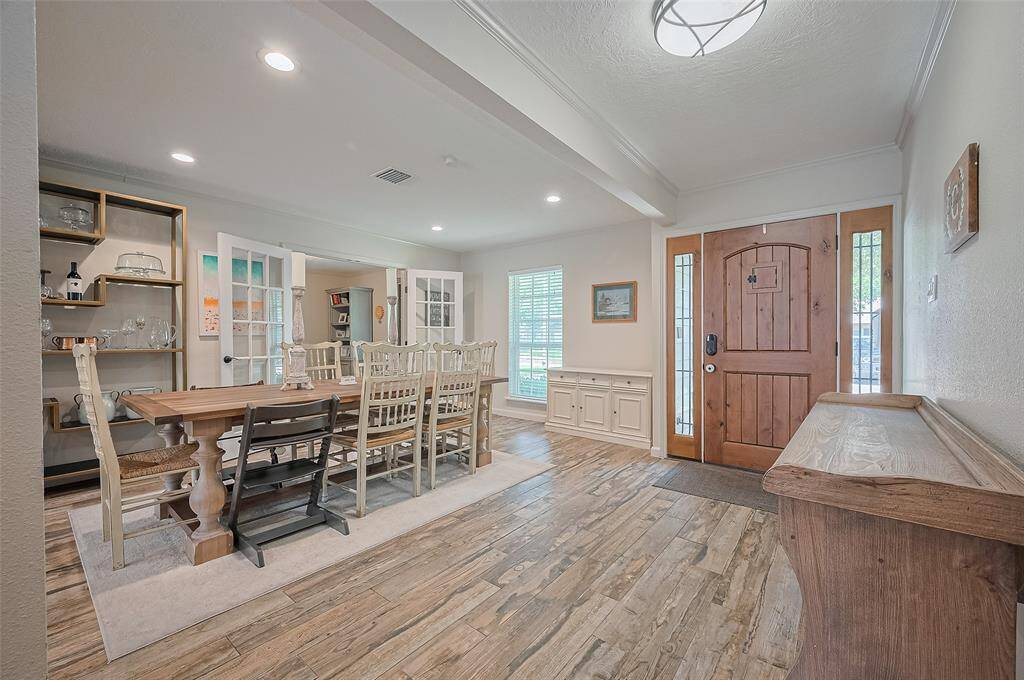 Step into the welcoming entryway and be greeted by an open floor plan featuring wood-look tile flooring, recessed lighting, crown molding, and an abundance of natural light.