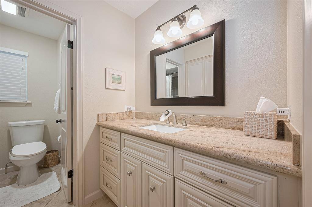 The secondary bathroom features excellent lighting, ample counter space, and plenty of storage—combining style and function for everyday convenience.