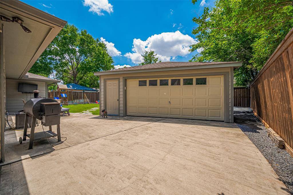 The detached garage is set back, creating a versatile space that enhances the use of the driveway and patio—perfect for extra parking, play, or entertaining.