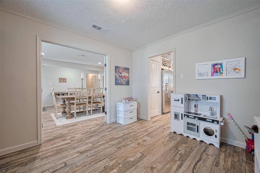 Just off the dining room, a versatile space can serve as a home office, playroom, or additional seating area. The room features double French doors, allowing it to be open or closed off as needed.