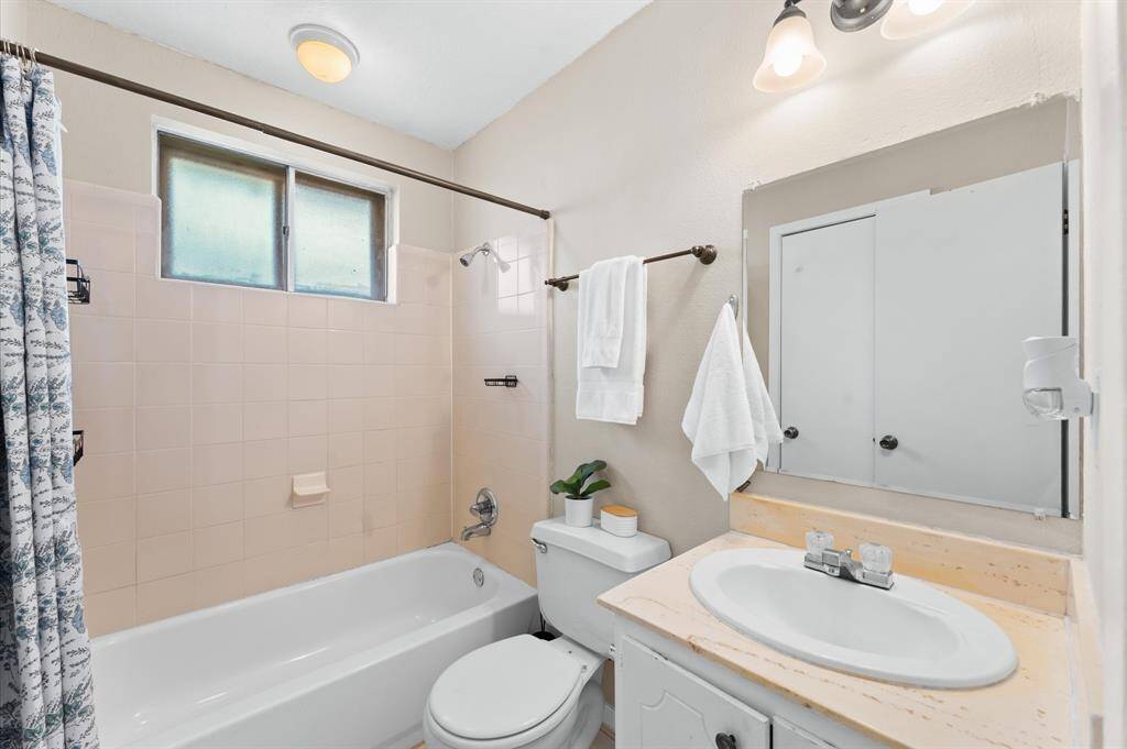 A convenient hall bath offers a tub and shower combination. It is easily accessible from the living room and secondary bedrooms.