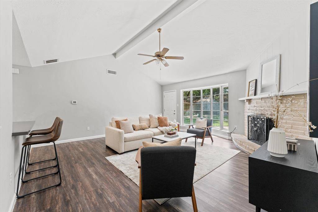 A bright and open living room rests under a vaulted ceiling and offers abundant natural light.
