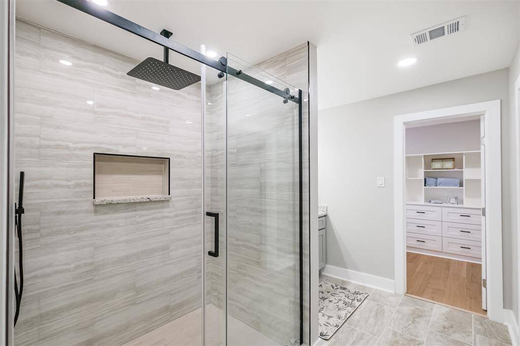 The beautiful, porcelain tile and granite give this room a true feel of serenity. Don't miss the convenient toiltery storage nook located inside this expansive shower.