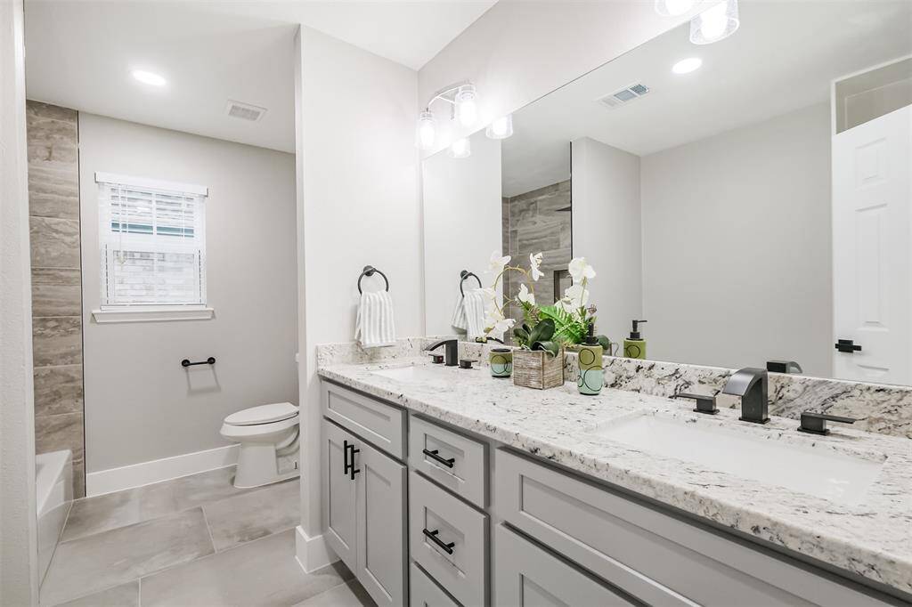 Double sinks and built in shelving across from the vanity highlight how much space is in this room.