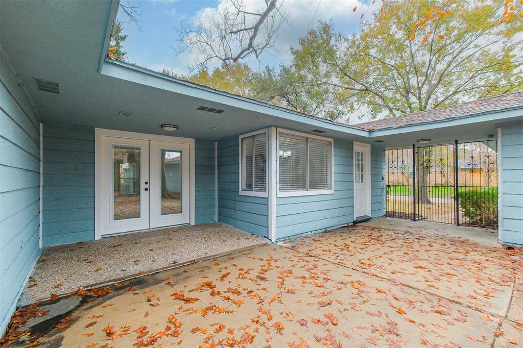 A closer look shows the french doors complete with integrated blinds and large covered patio. The privacy gate provides security and access to the side yard.