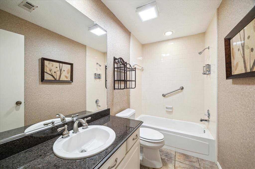 Secondary bathroom with tub/shower combo and granite countertops.