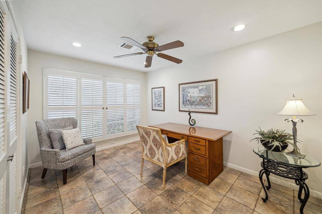 Fourth bedroom with plantation shutters and recessed lighting.