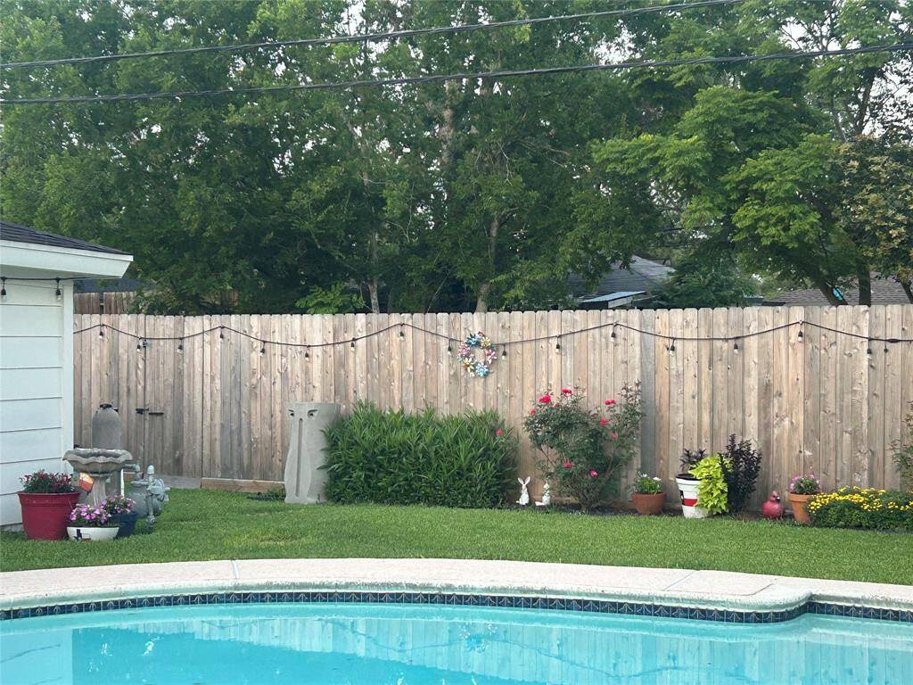 There is lighting around the entire backyard with green space behind the back fence