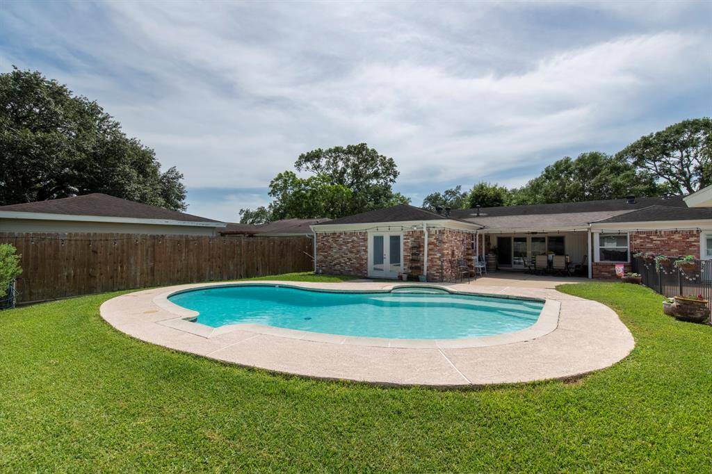 lA large and spacious backyard with a pool.