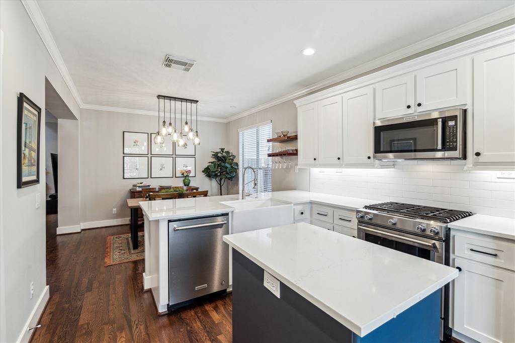 This kitchen sparkles with white quartz countertops, stainless steel appliances and a porcelain farmhouse sink.  All cabinet doors and drawer fronts throughout the home were replaced in 2021 and have soft close hinges.