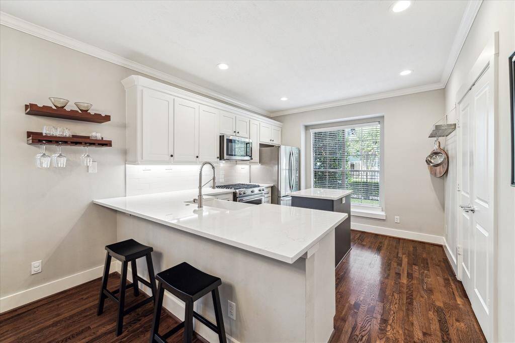 Look at all of this space in this peppy white kitchen!  Need an extra work from home space?  The kitchen corner is just the right spot.  Raised panel double doors on the right in this photo open to the large pantry.