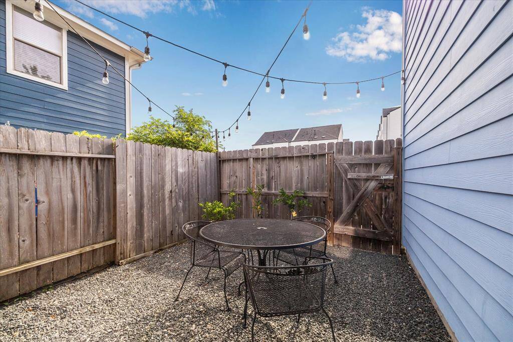 Even more outdoor space in this low maintenance back yard. Covered patio (not pictured) is great for BBQ!. Twinkling party lights stay with the property. The gate leads to the alleyway behind the garage. Cement board siding is on all sides of this fine home.