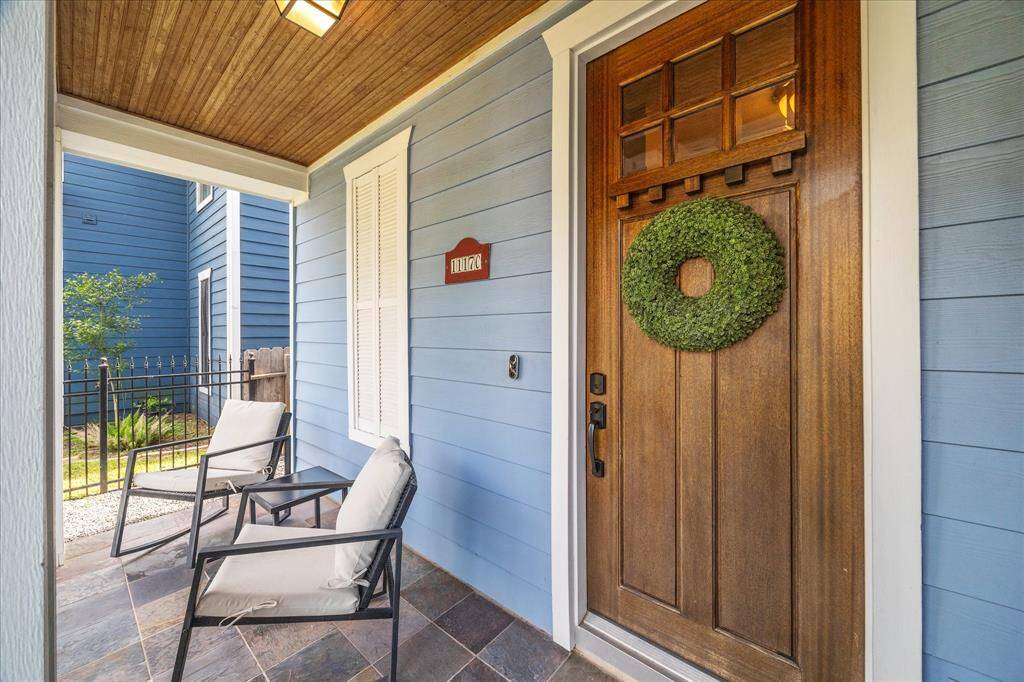 Relax on this perfect front porch.  Timeless slate tile floor, stained beadboard ceiling and a quality front door with black hardware.
