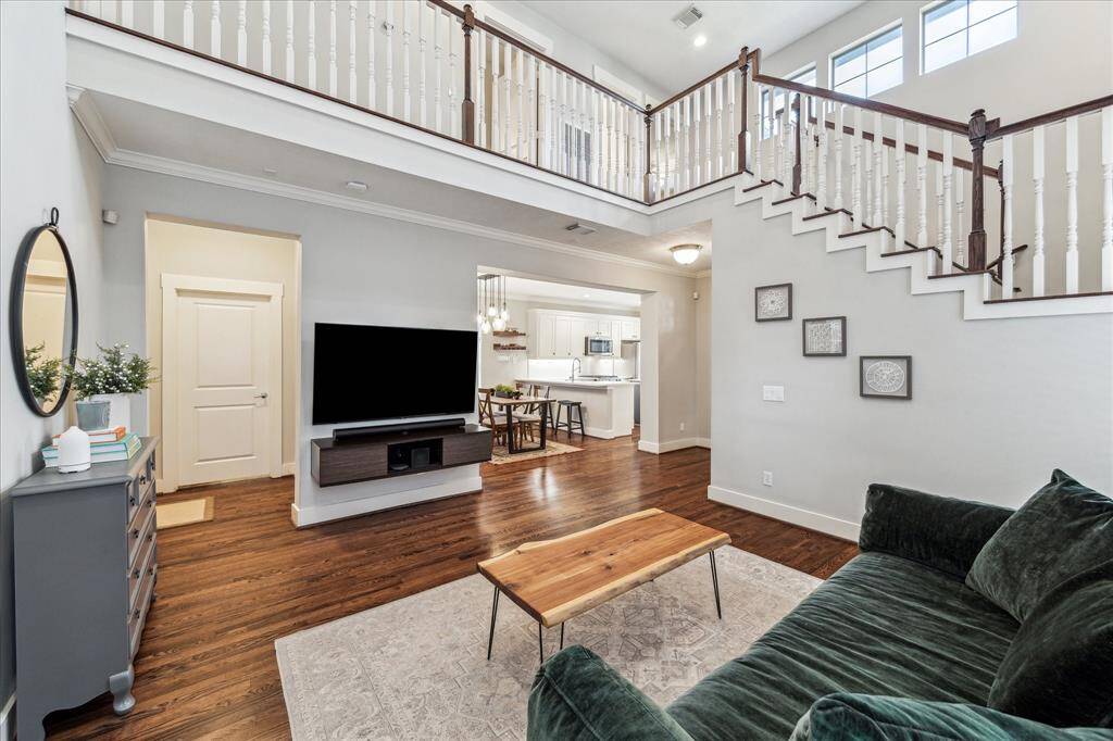 This view of the living room shows the expanse of space around the first level and up to the second floor.  Abundant natural light streams into this fine home.