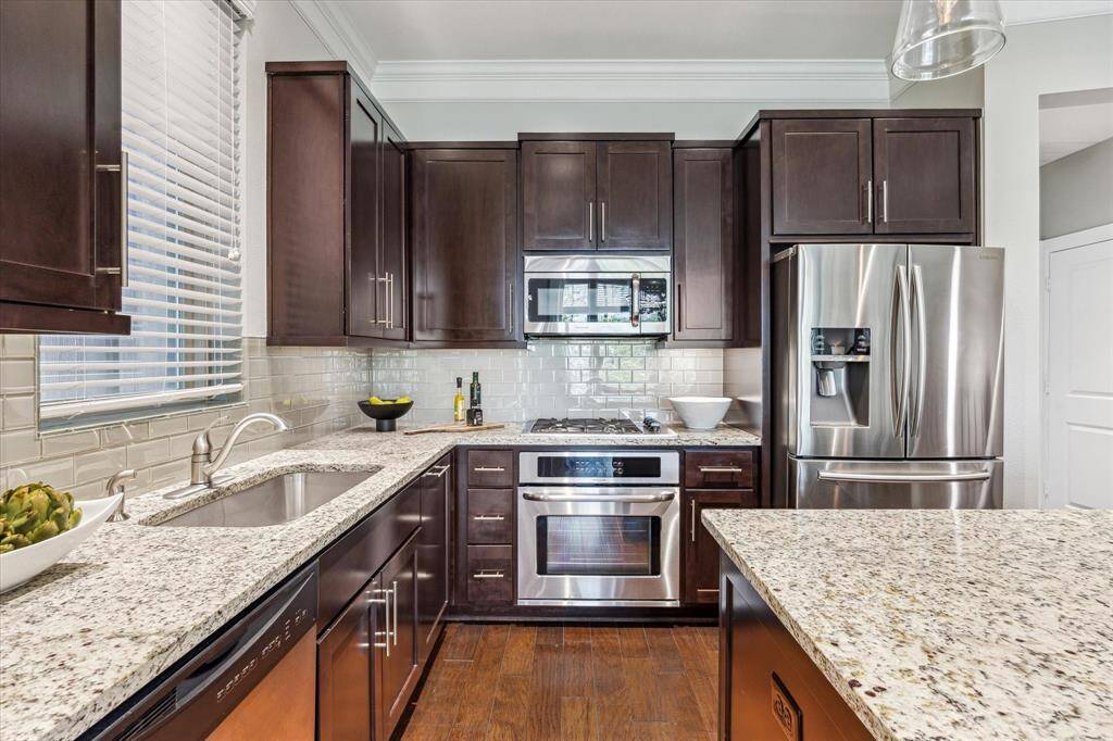 Stainless steel Frigidaire appliances, including a dishwasher, microwave, and 4-burner gas range, add both style and functionality.