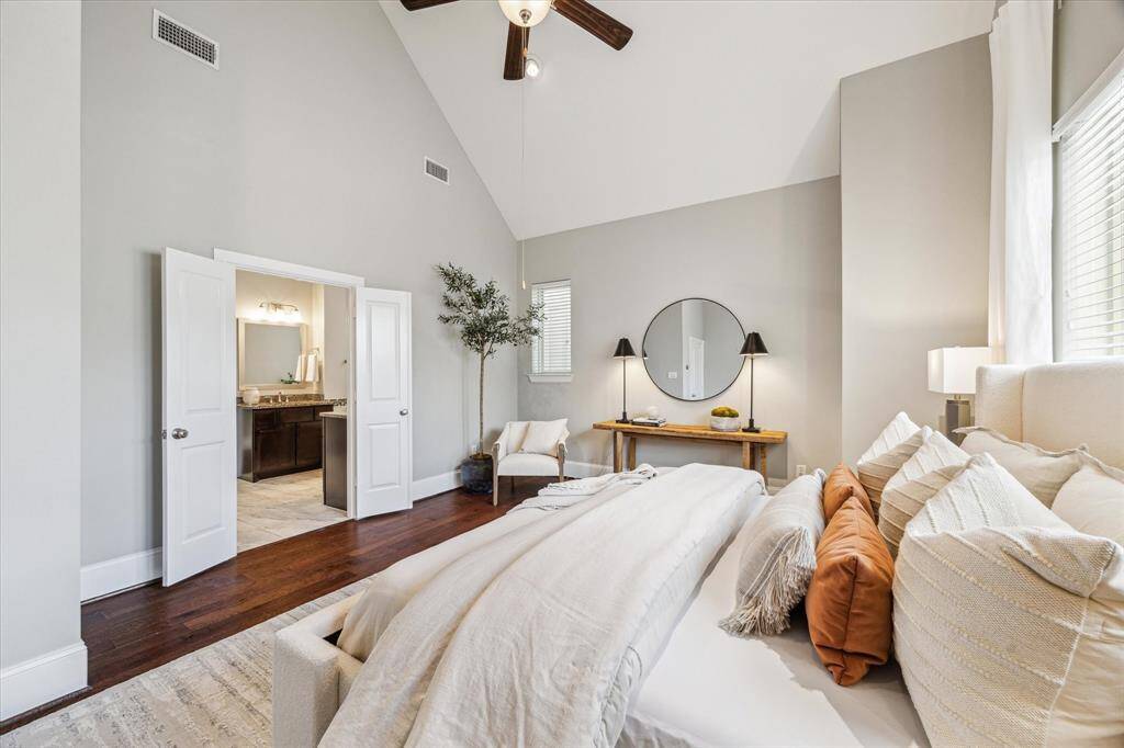 An alternate view of the primary suite offers a glimpse into the spa-inspired bath through the elegant double-door entry.