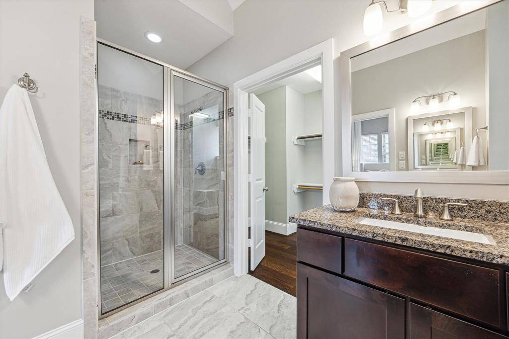 Additional highlights in the primary bath include recessed lighting, modern tile flooring, and a spacious walk-in closet.