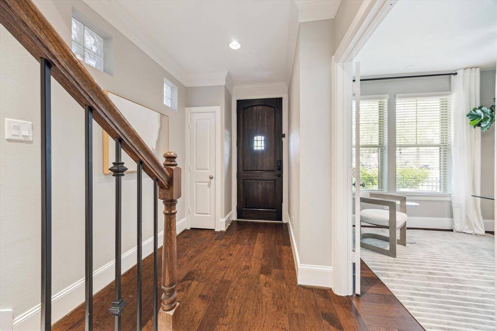 Welcoming entryway with high ceilings, convenient coat closet, access to the attached 2-car garage, and glass block accents that fill the space with natural light as you transition to the upper levels.