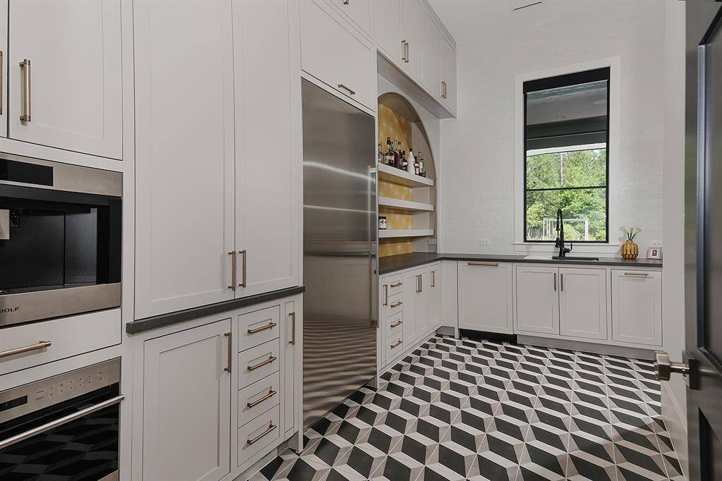 This gorgeous scullery features a built-in Wolf espresso maker, 2nd dishwasher, sink and fridge, as well as a built-in microwave.