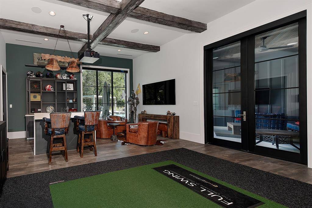 This sound proof game room (or man cave) downstairs has a full bar and golf simulator!