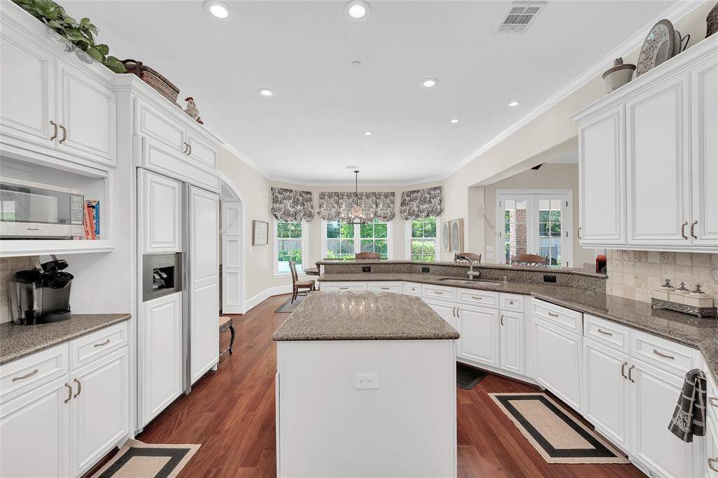 Large kitchen with tons of cabinetry, double ovens, island and breakfast bar