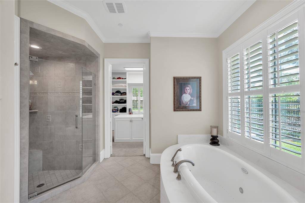 Additional view of the primary bathroom featuring walk-in shower, tub and generously sized walk-in closet