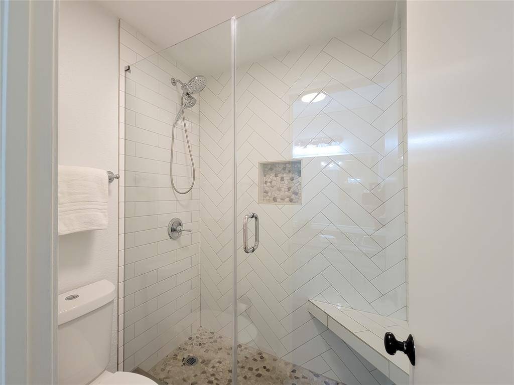Tastefully updated shower features a shelf, shampoo niche and spa-like amenities.