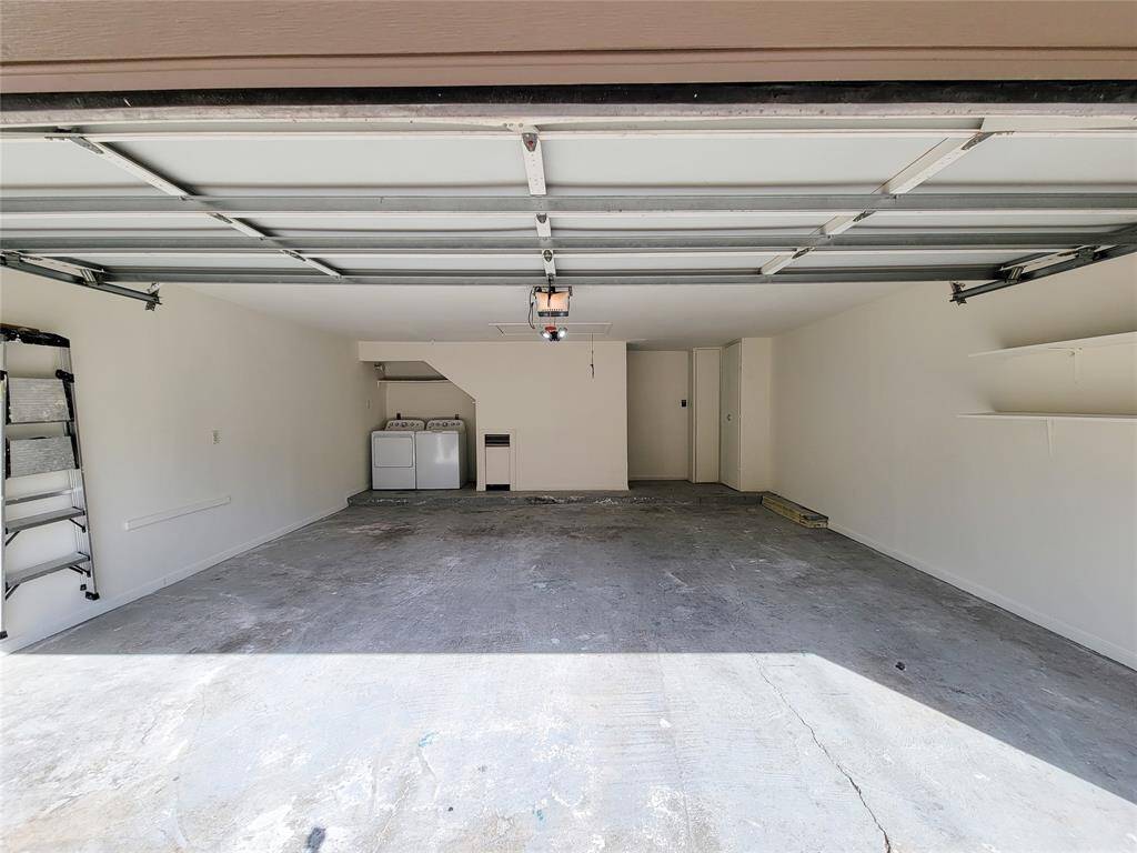 The recently painted, oversized 2-car garage (20' deep x 19' wide) features a laundry area, shelving and storage, as well as attic access.