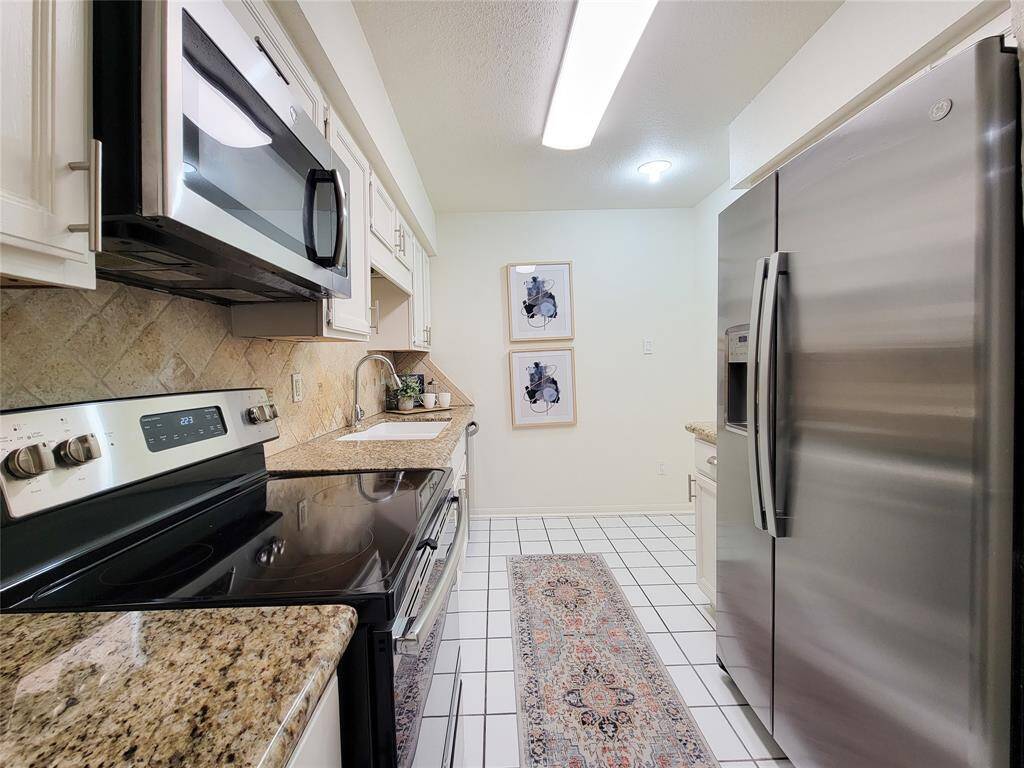 The kitchen has SS appliances, granite countertops, tile flooring and ample cabinet space with pantry.The GE stainless steel side by side refrigerator with water/ice dispenser is included. There is also space for a bistro table or bar cart in the corner.