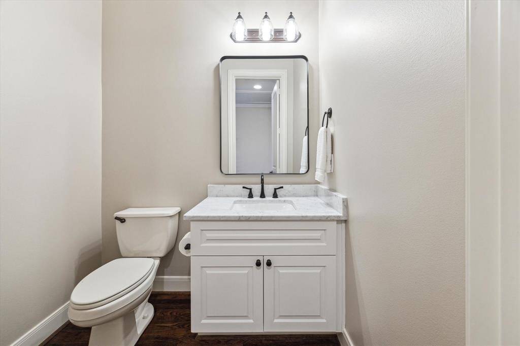 This stylish powder bath, conveniently located on the second floor, features a marble countertop, sleek black fixtures, and elegant finishes—perfect for guests.