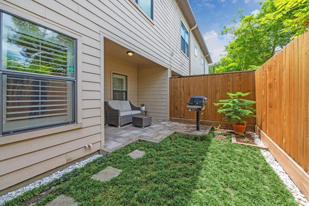 A charming green space with stone pavers, fresh landscaping, and a covered sitting area offers an inviting extension of your living space—ideal for pets, play, or enjoying sunny Houston days.