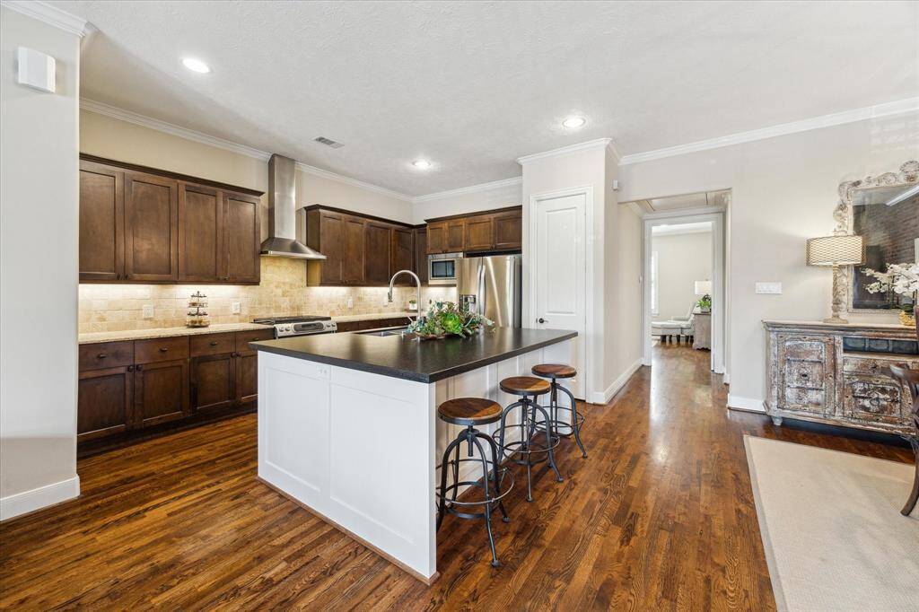 The heart of the home—this open kitchen features a spacious island with bar seating, perfect for casual meals or entertaining, all overlooking the connected living and dining areas.