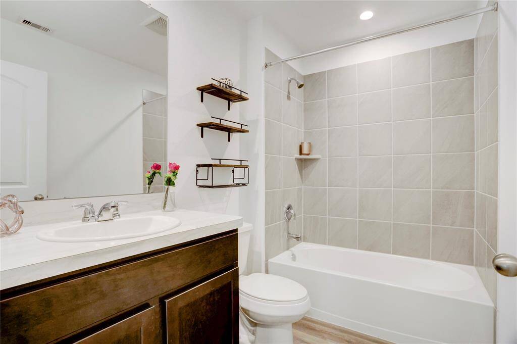 The secondary bath also has a vanity that echoes the style of the primary, plus a shower-tub combination for added versatility.