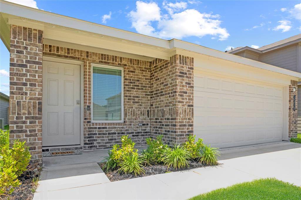 A closer look at the front entrance reveals a quaint covered porch framed by tidy plant beds. This entryway adds just the right touch of warmth and shelter as you arrive home.