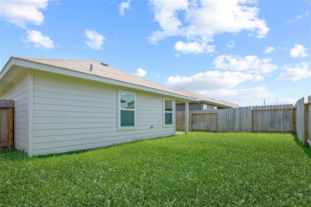 The expansive backyard is fully fenced and blanketed in vibrant grass—offering endless potential for play, gardening, or entertaining under the open sky.