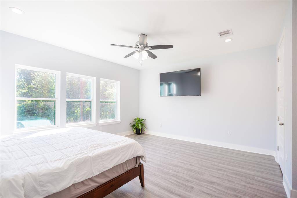 Primary bedroom with abundant windows allowing natural light.