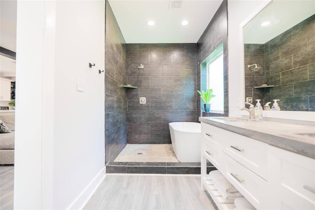 View of primary bathroom with standing shower and soaking tub.