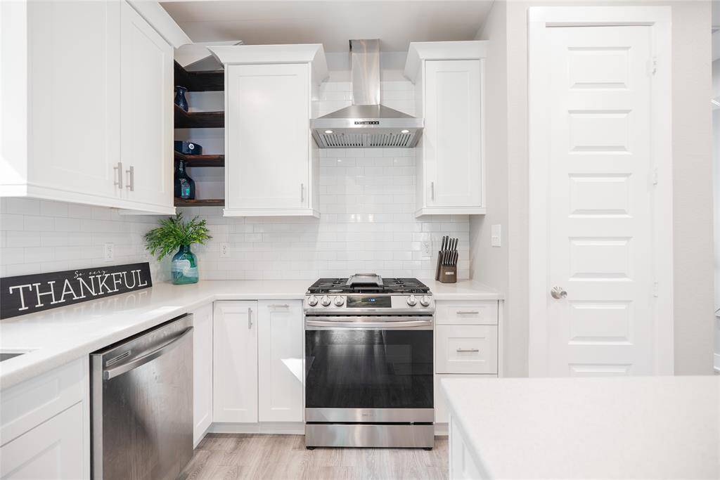 Gas range with range hood, dishwasher and plenty of cabinet storage.