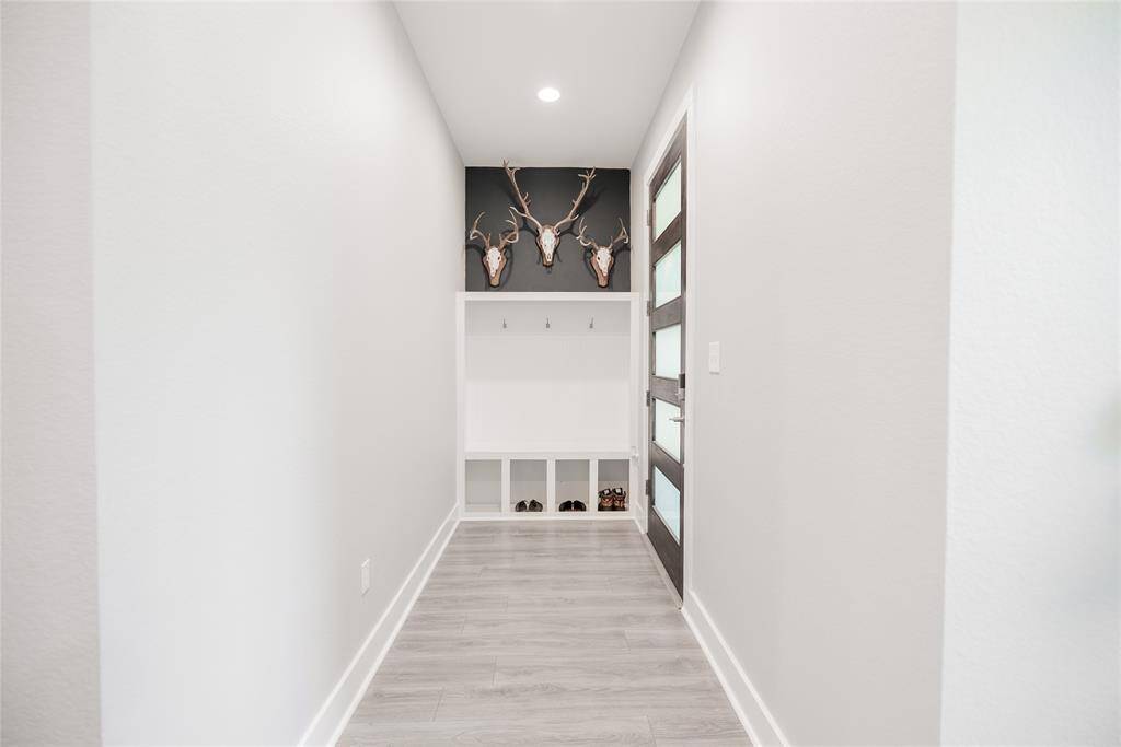 Front door hallway with modern built in hall tree with bench seating and shoe nooks.