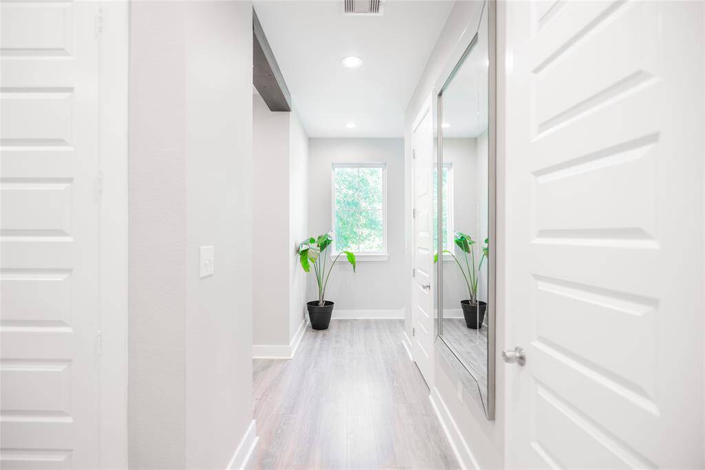 View of hallway from kitchen with half bath on the right.