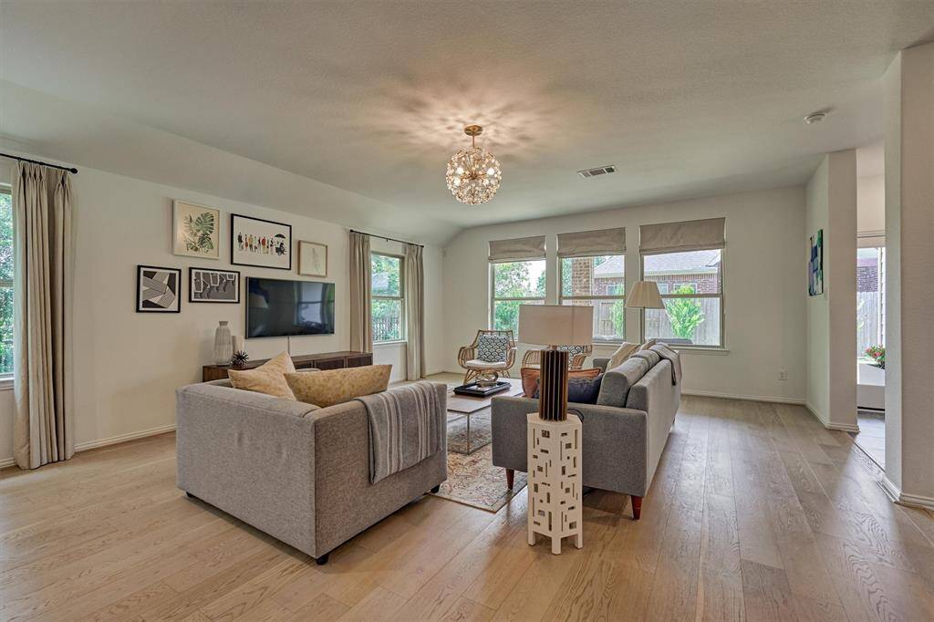 On trend wood flooring combined with the wall of windows make this room feel light and bright!